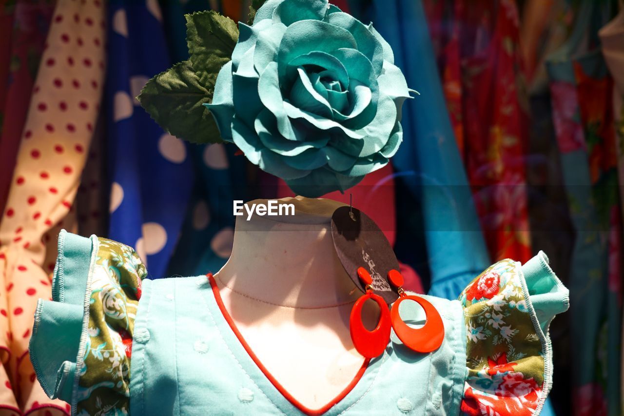Close-up of artificial turquoise flower on mannequin in store
