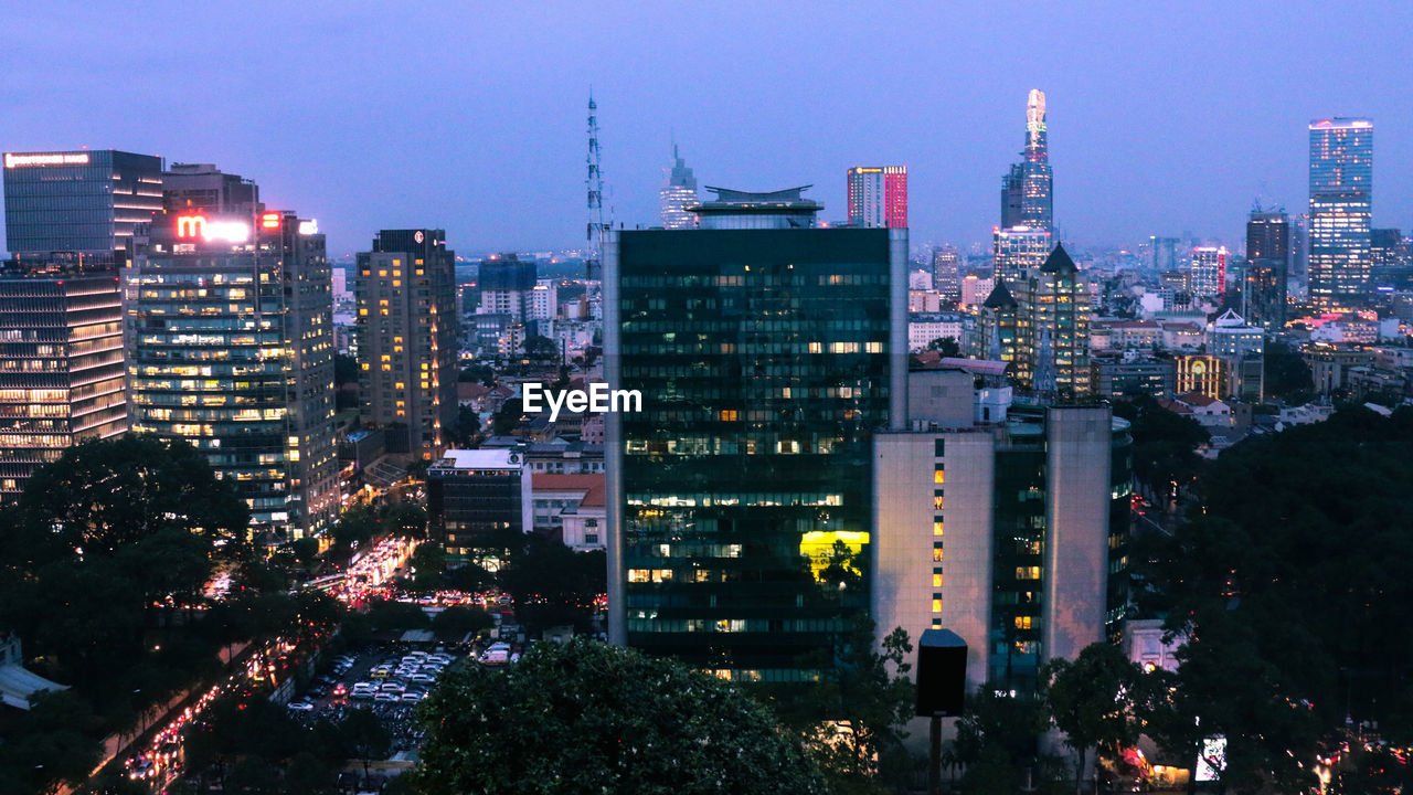 Illuminated buildings in city against sky at night