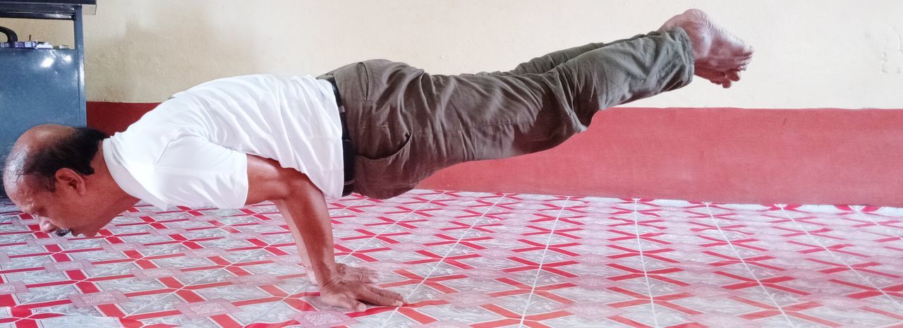 SIDE VIEW OF MAN SKATEBOARDING ON SOFA