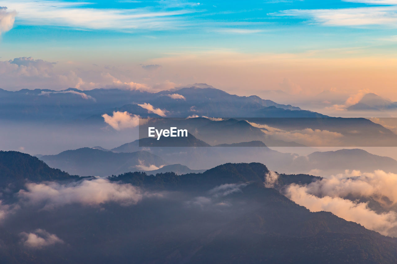 Scenic view of majestic mountains against sky during sunset