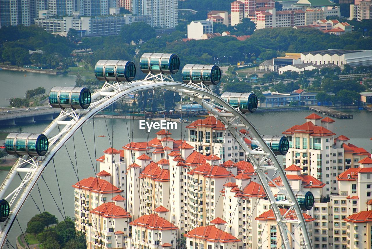 High angle view of ferris wheel in front of city buildings