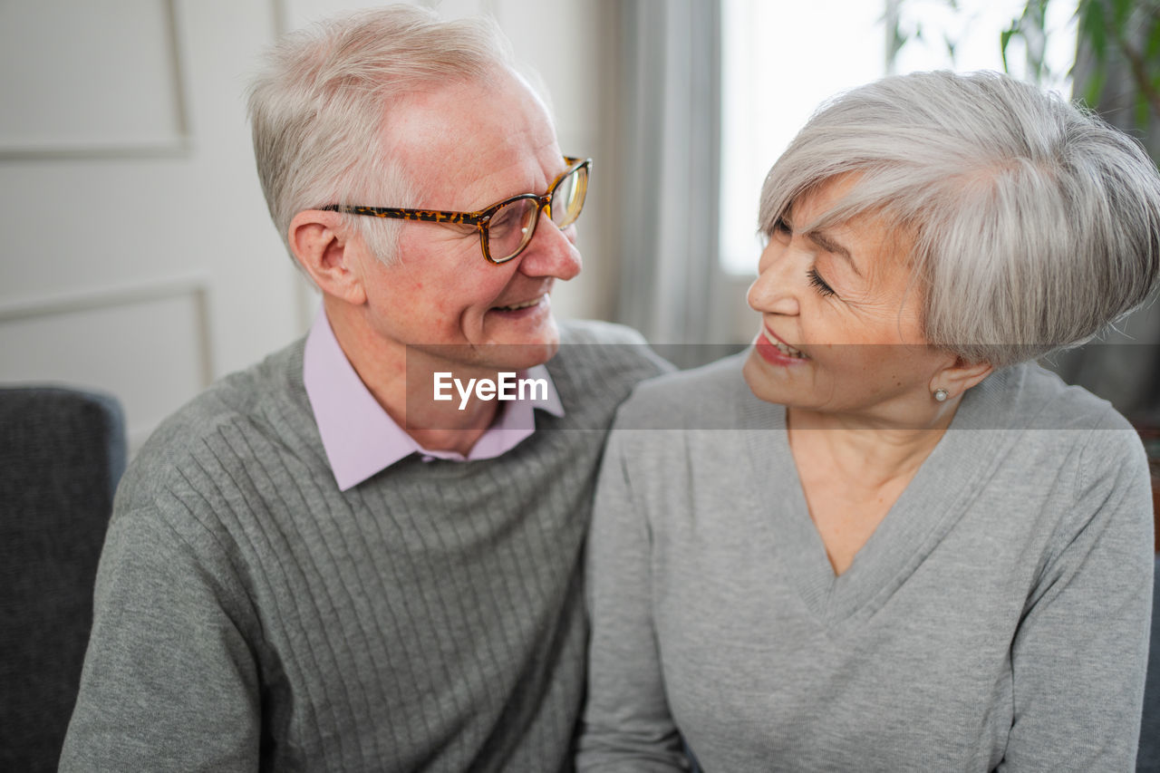 portrait of young woman using mobile phone while sitting at home
