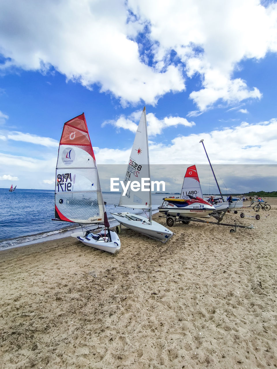 SAILBOAT MOORED ON SHORE AGAINST SKY