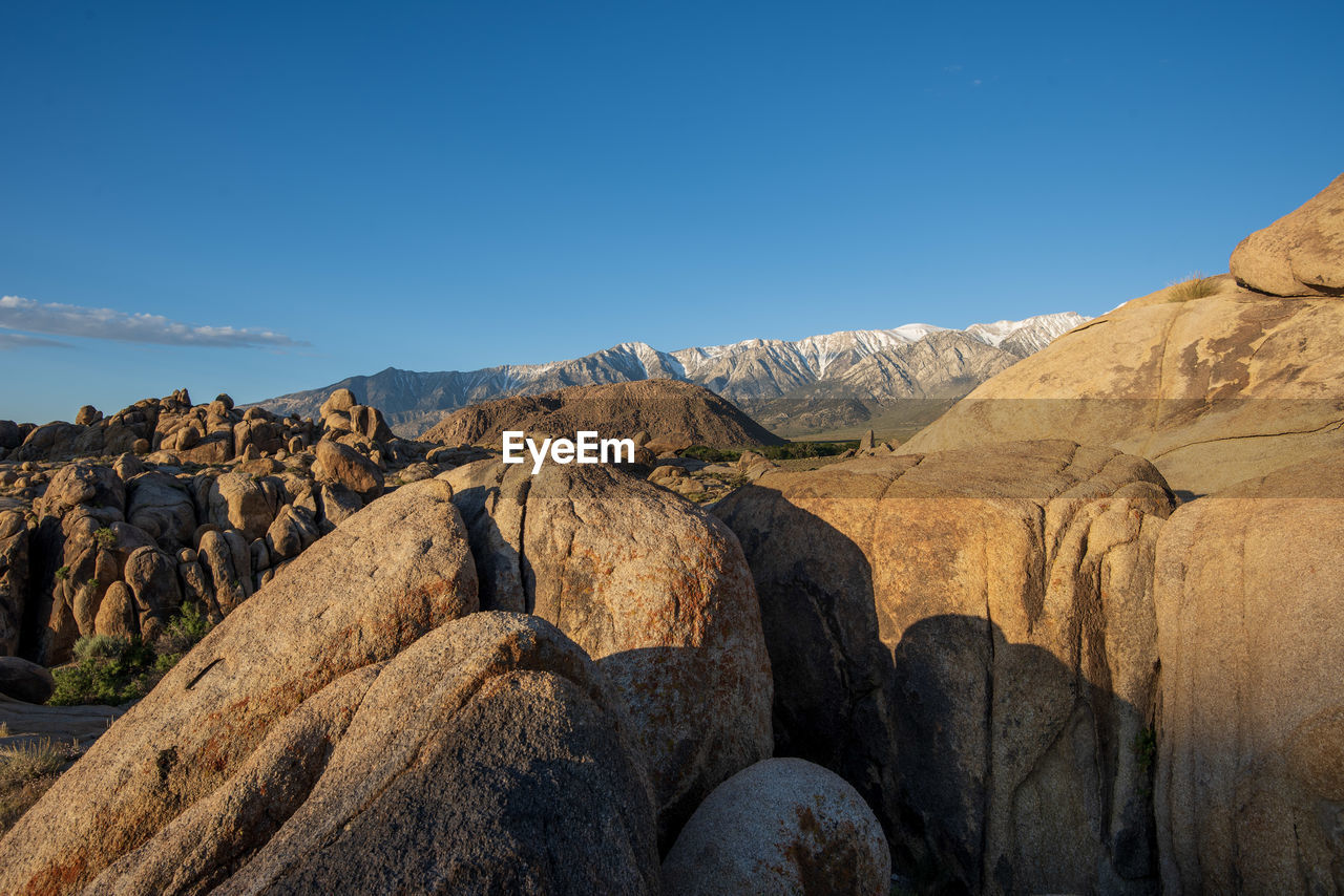 Rock formations on landscape against blue sky