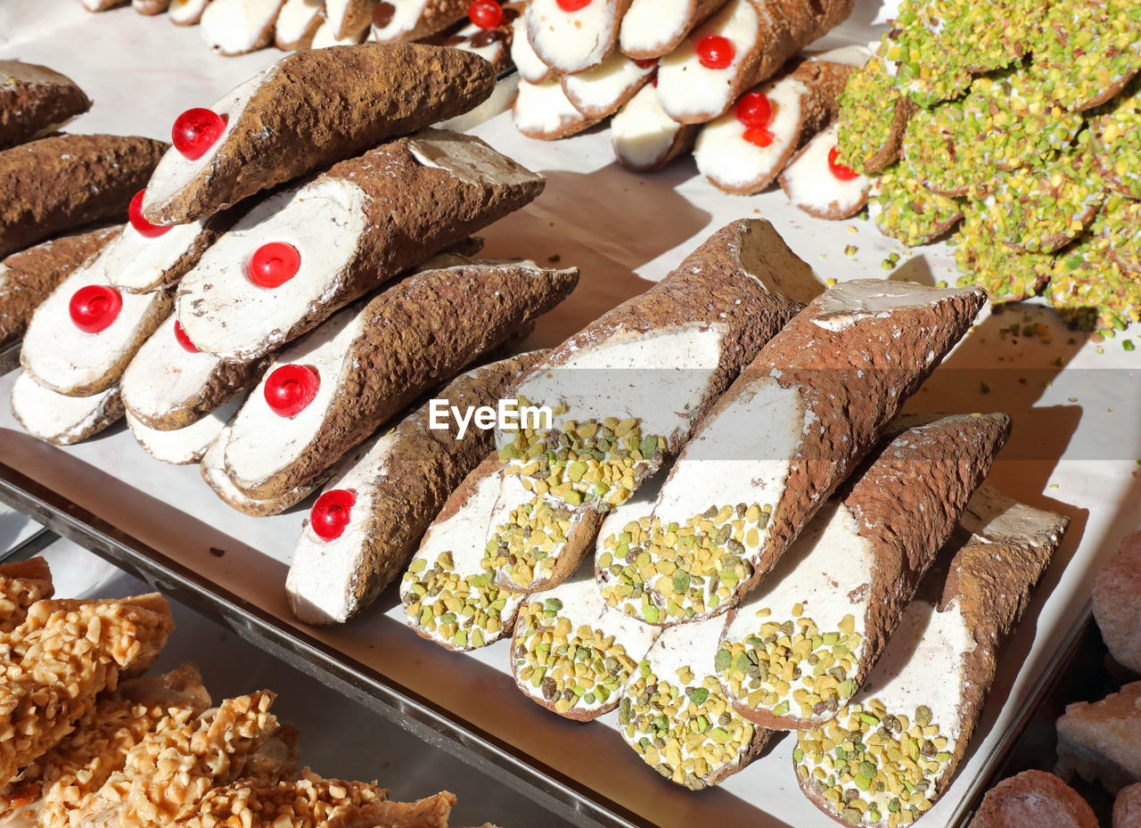 Many pastries with pistachio and cherries for sale in the italian pastry shop
