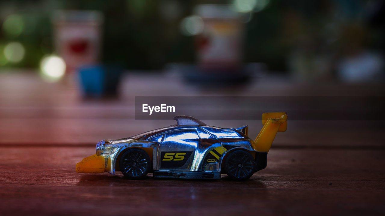 car, vehicle, toy, toy car, sports car, childhood, land vehicle, supercar, sports, yellow, auto racing, mode of transportation, racing, motor vehicle, table, race car, selective focus, transportation, race track