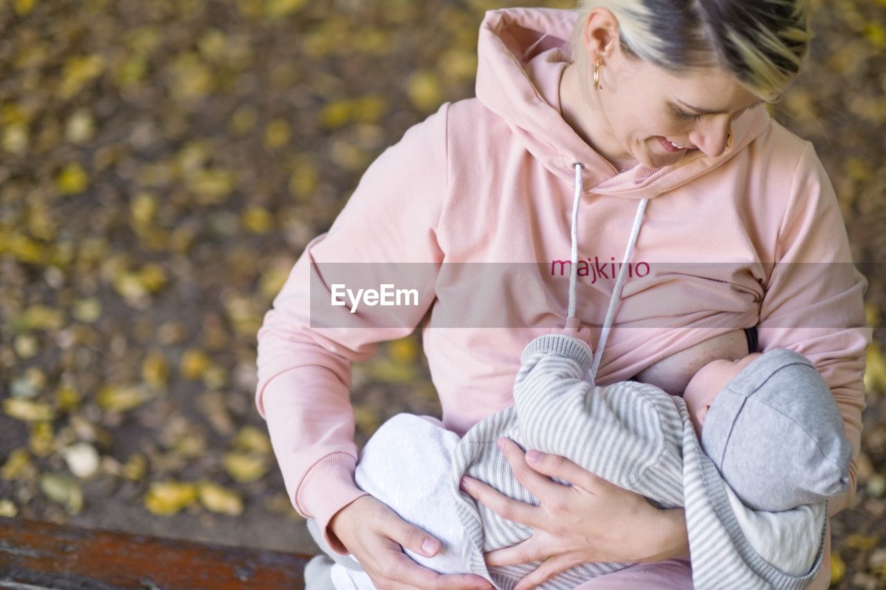 High angle view of woman looking at baby while breastfeeding 