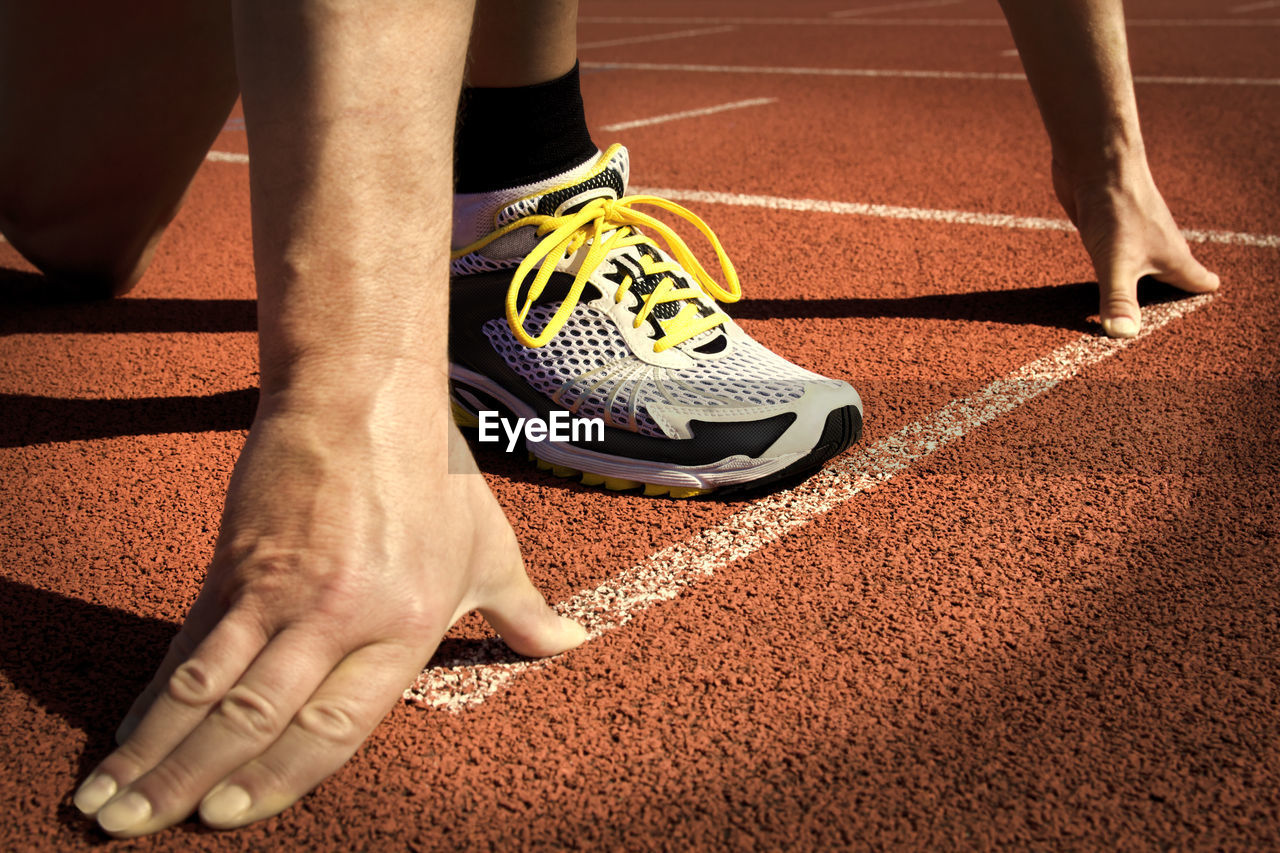 Low section of man standing at starting line