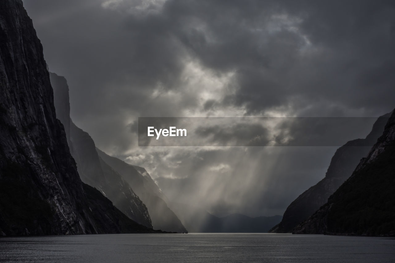 Scenic view of lysefjord by mountain against sky