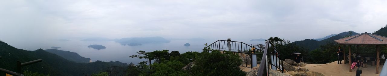 PANORAMIC VIEW OF TREES AND MOUNTAINS AGAINST SKY