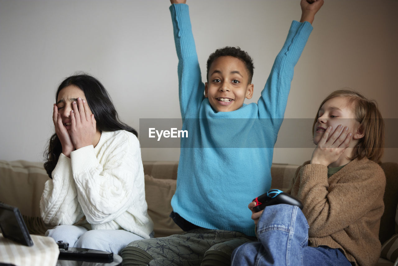 Children playing video games at home and celebrating