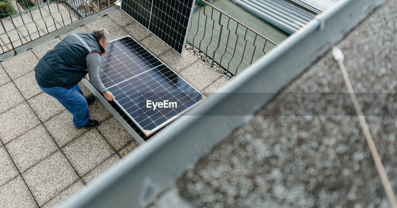 High angle view of engineer inspecting solar panel