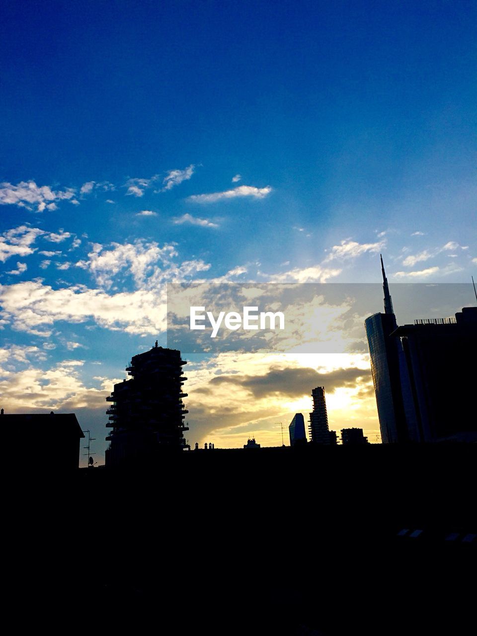 Low angle view of silhouette buildings against sky at sunset