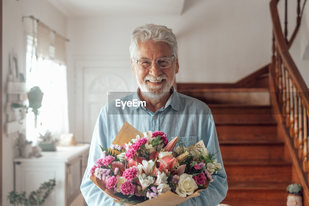 Portrait of man holding flower bouquet