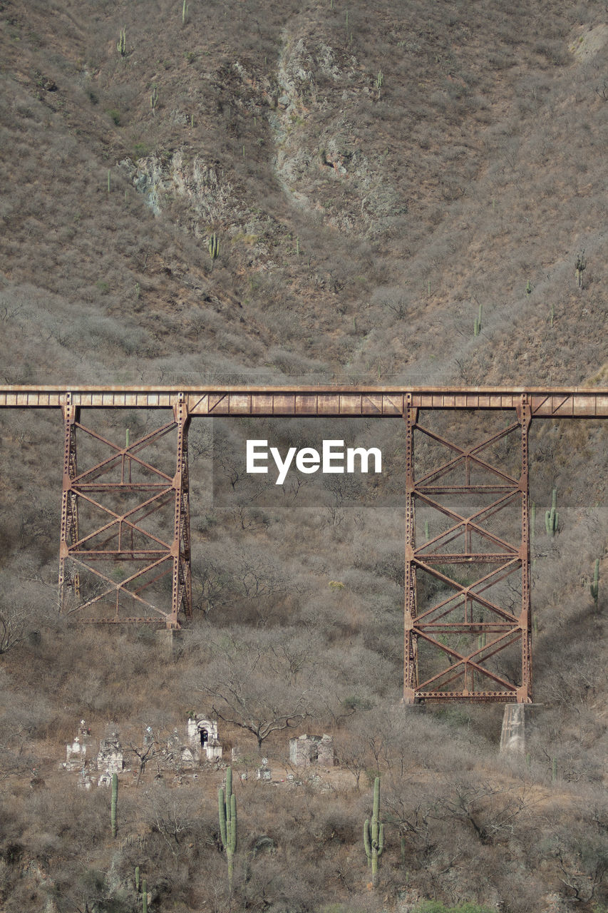 Old railway bridge over cemetery against andes mountain