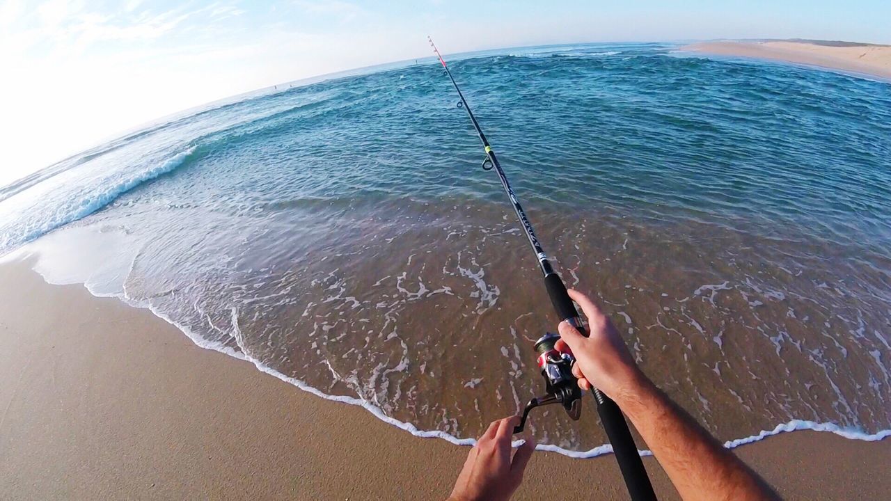 CLOSE-UP OF TWO PEOPLE FISHING IN SEA