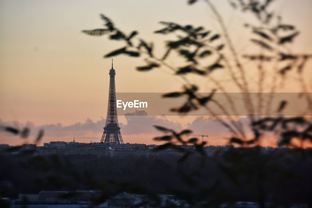 Distance view of eiffel tower against sky during sunrise