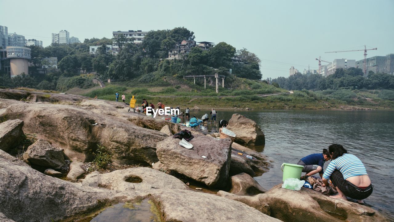 People washing clothes by river