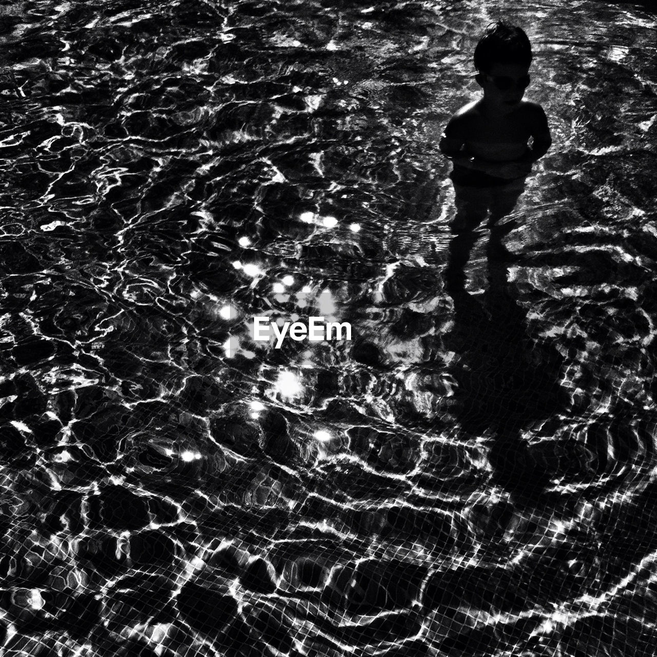 High angle view of boy standing in water