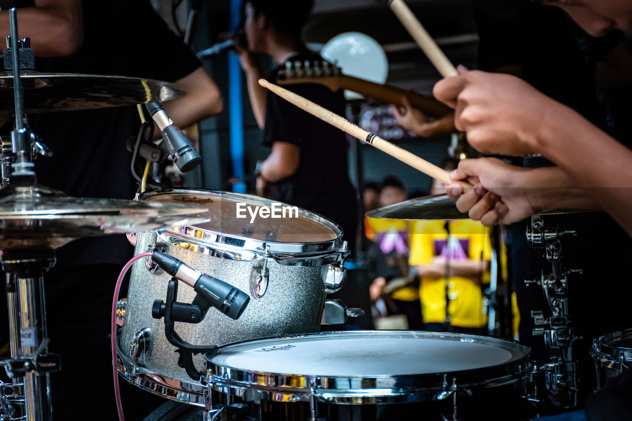 Cropped image of man playing drum at music concert