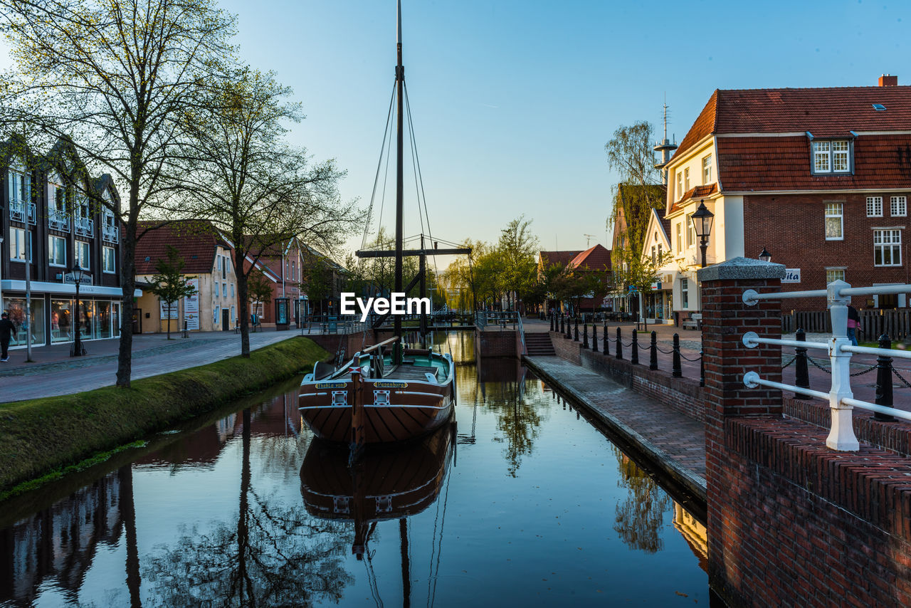 Canal amidst buildings against sky