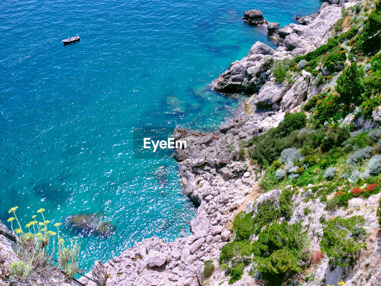 HIGH ANGLE VIEW OF ROCKS ON SEA