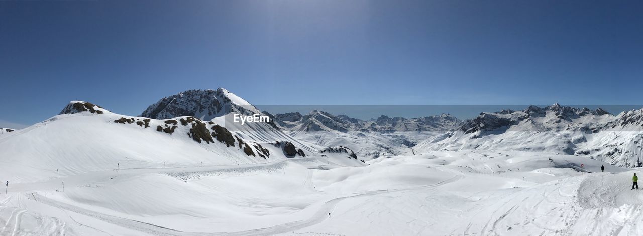 Scenic view of snowcapped mountains against clear blue sky