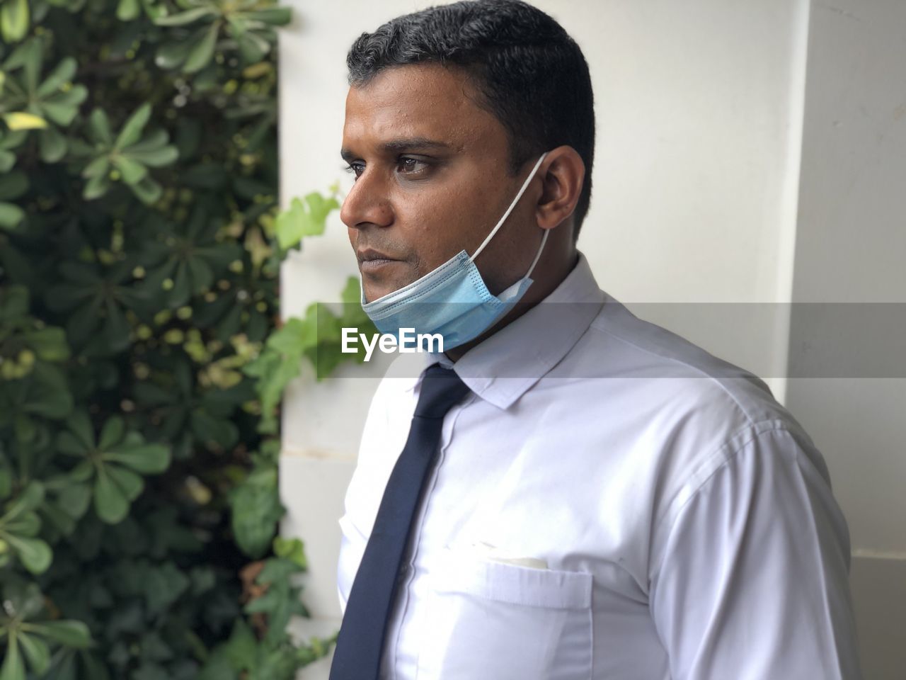 Portrait of young man with face mask looking away