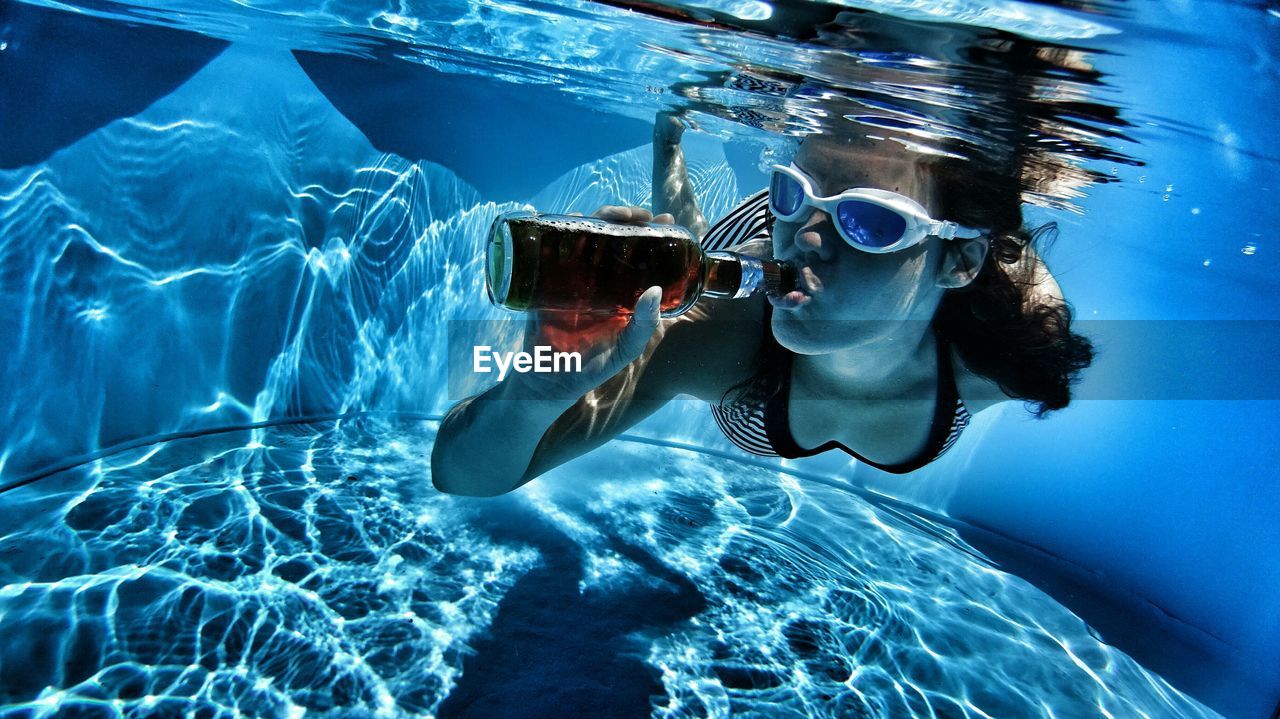 Young woman drinking underwater