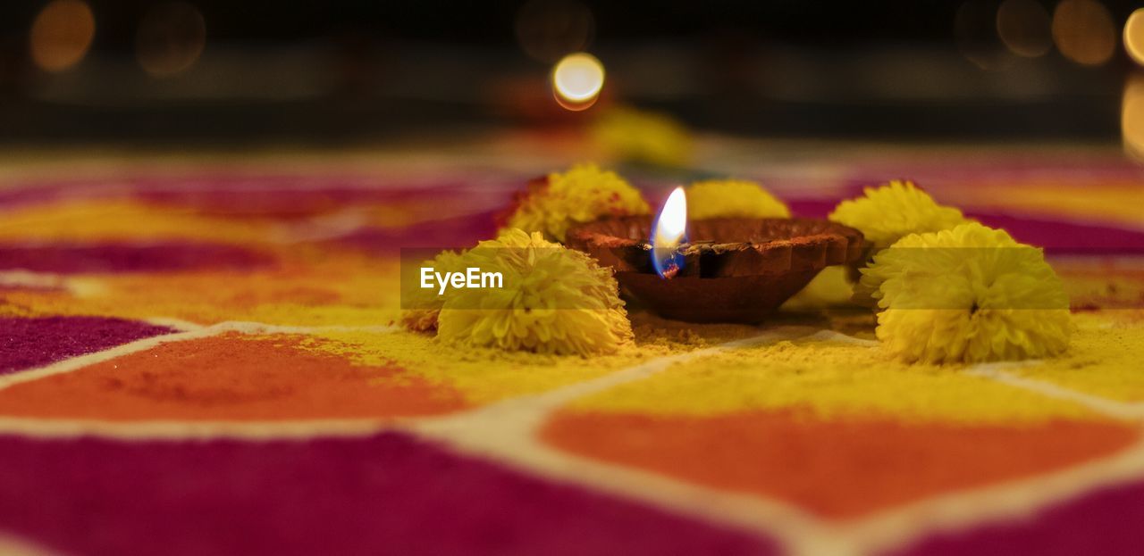 Close-up of diya on rangoli during diwali