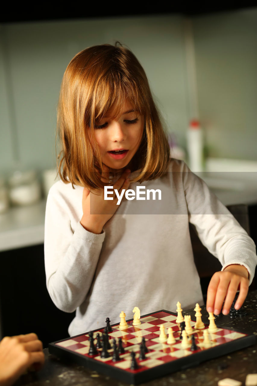 Children playing chess at home kitchen