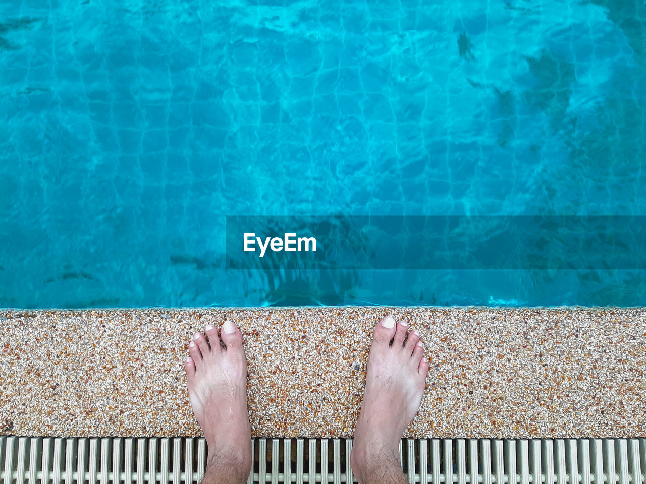 Low section of man standing at poolside