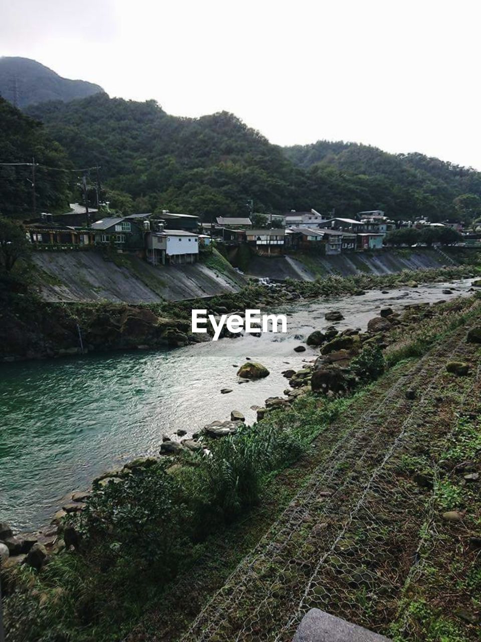 Scenic view of river by mountains against clear sky