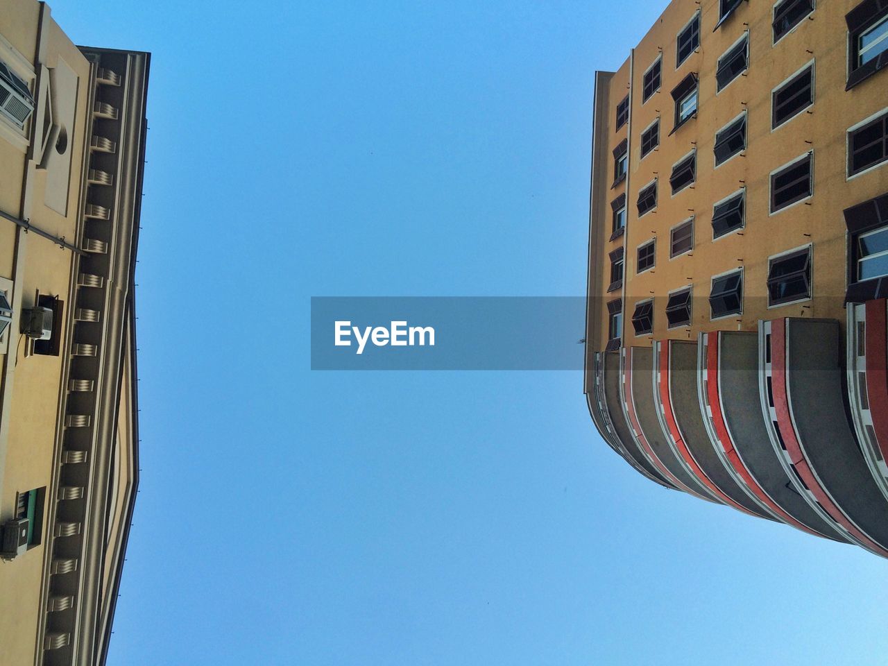 LOW ANGLE VIEW OF BUILDINGS AGAINST BLUE SKY