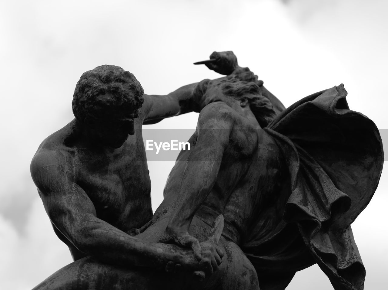 LOW ANGLE VIEW OF STATUE OF BIRD PERCHING ON ROCK