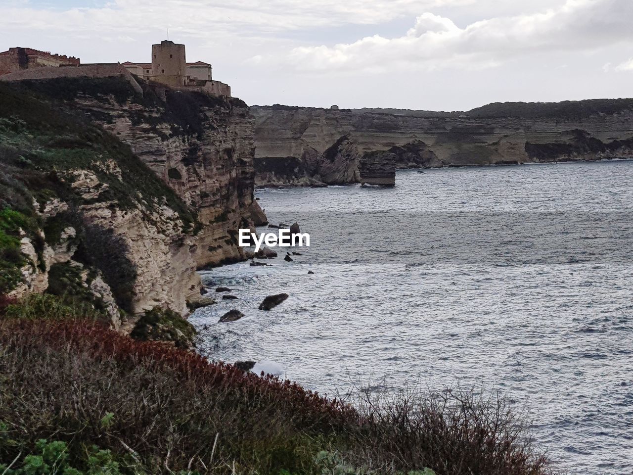 VIEW OF CLIFF BY SEA AGAINST SKY