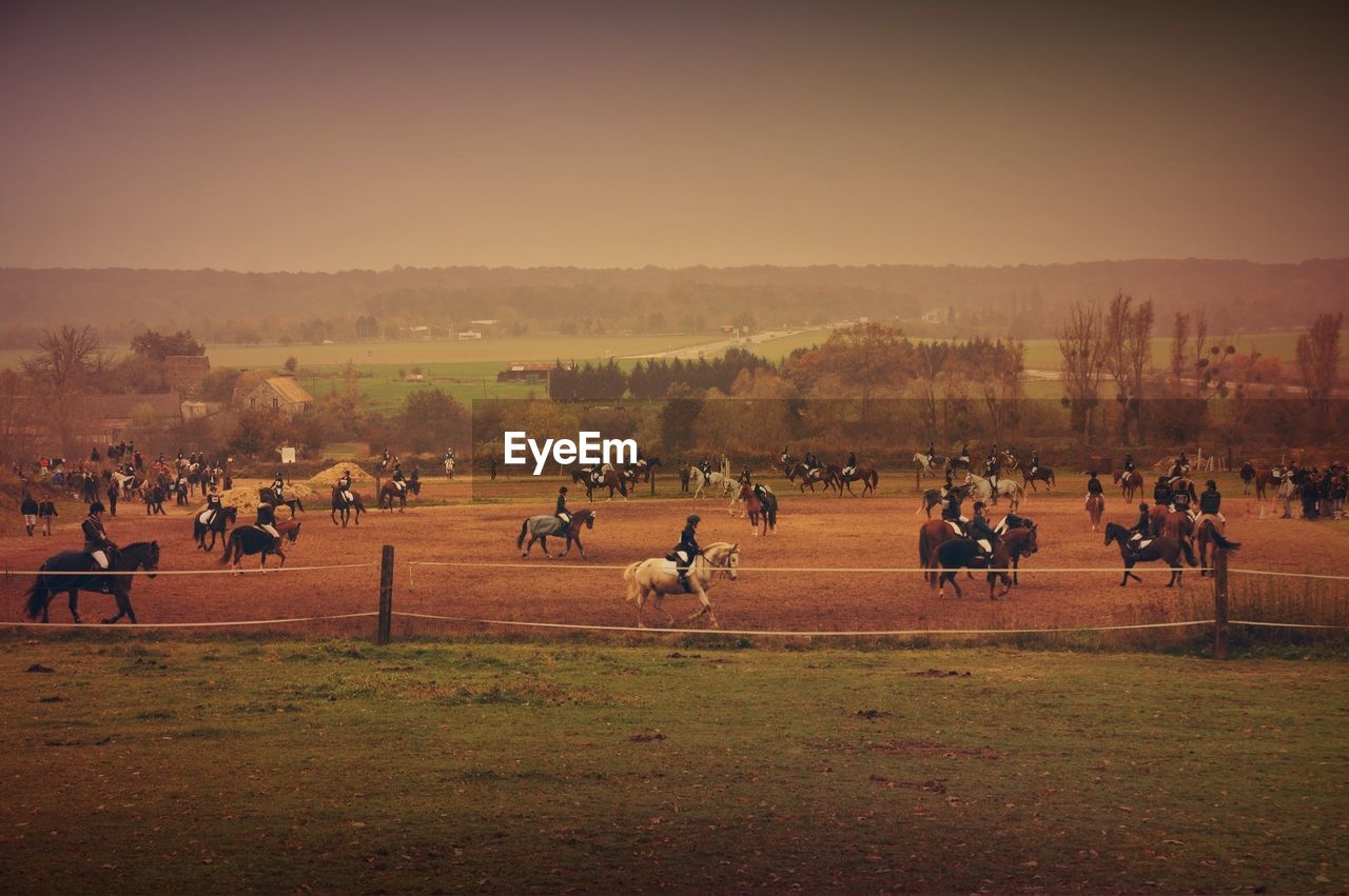 Group of people horseback riding in field