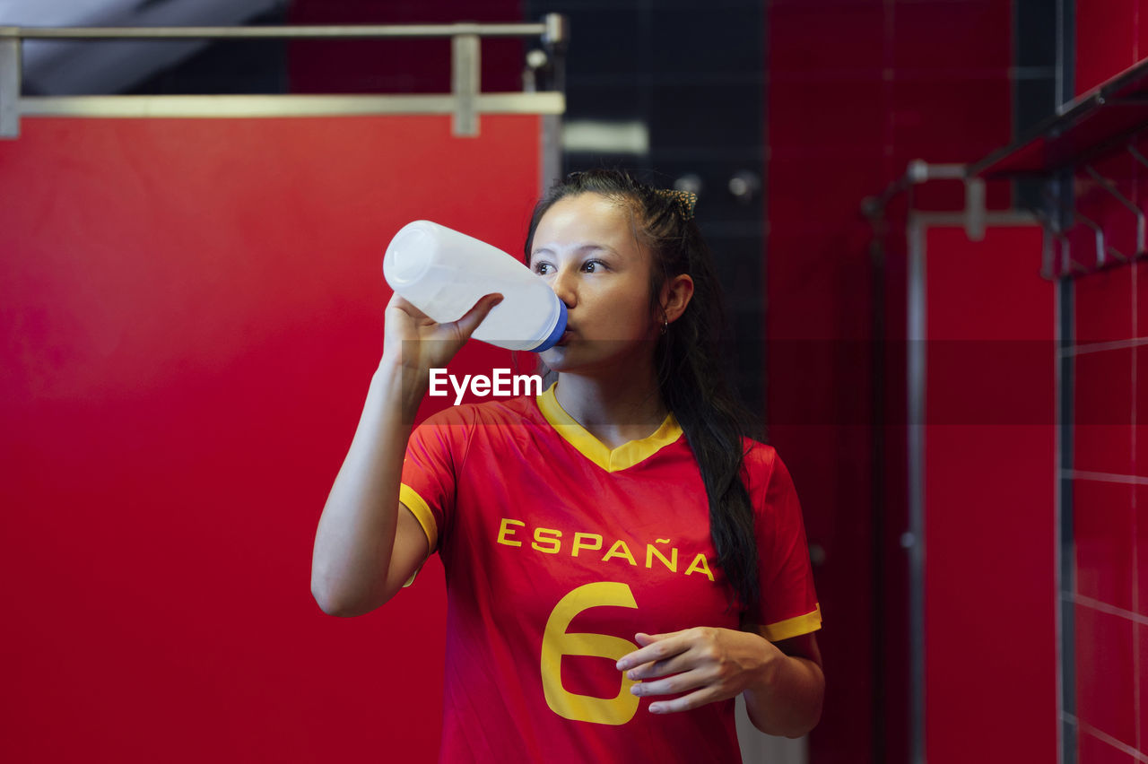 Young player drinking water in locker room