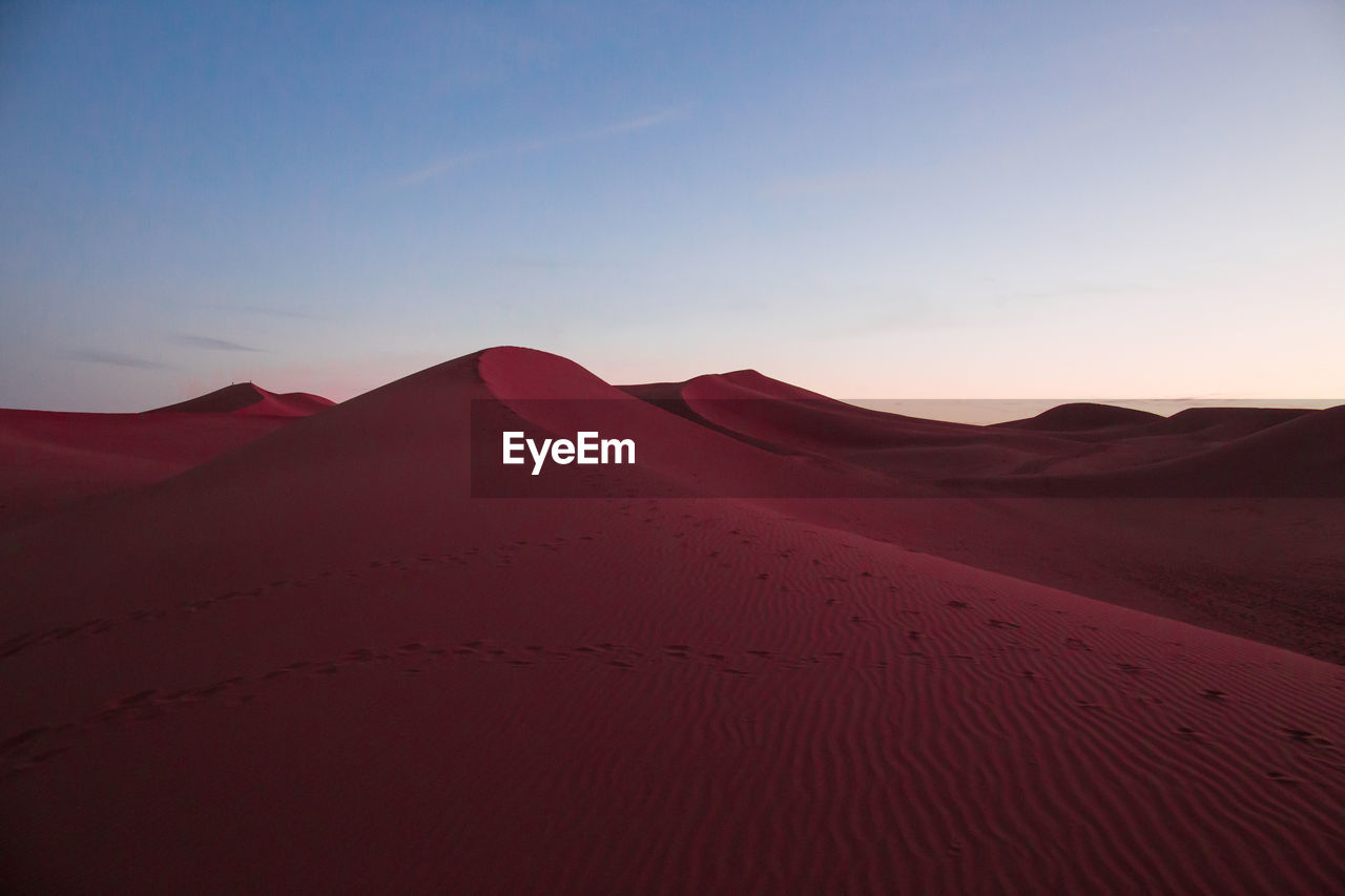 Scenic view of desert against sky during sunset