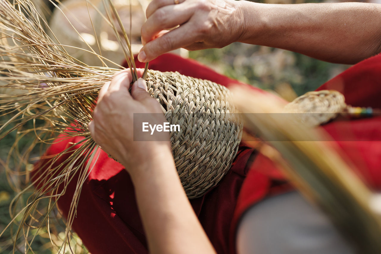 Hands of artisan making basket with esparto grass