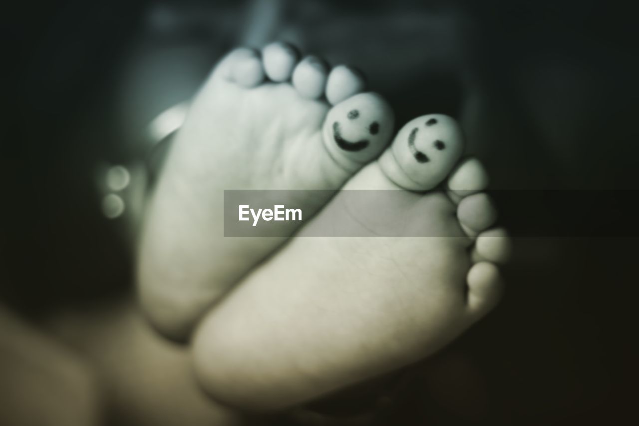 Low section of child with anthropomorphic faces on toes
