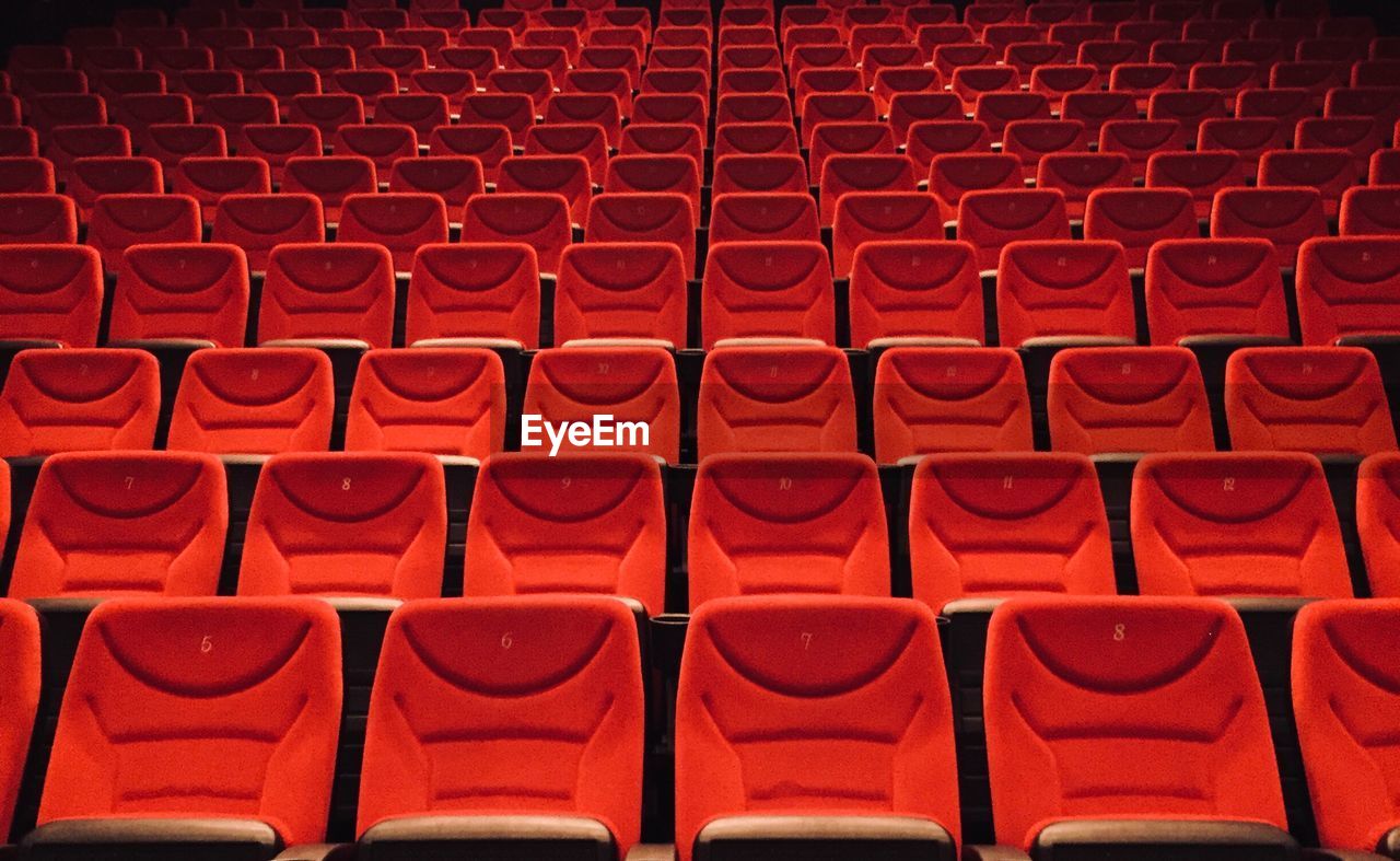 Full frame shot of empty chairs with numbers in movie theater 