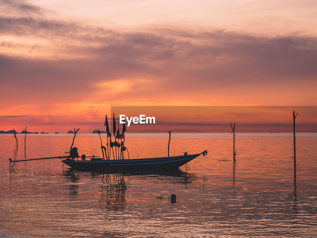 Sunset in beautiful twilight orange sky with local's fishing boat silhouette. koh samui , thailand.