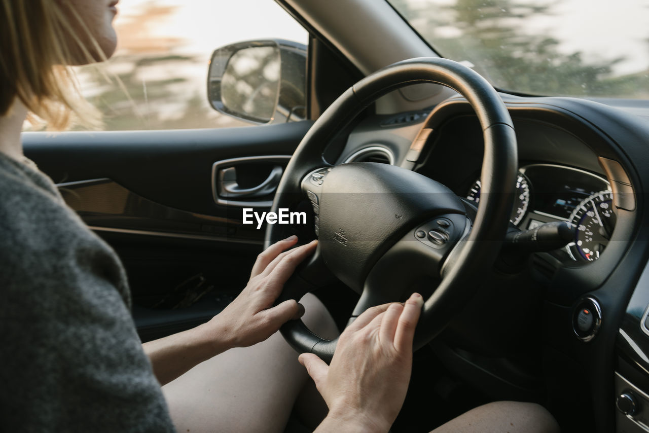 Inside view of woman driving in big sur at sunset