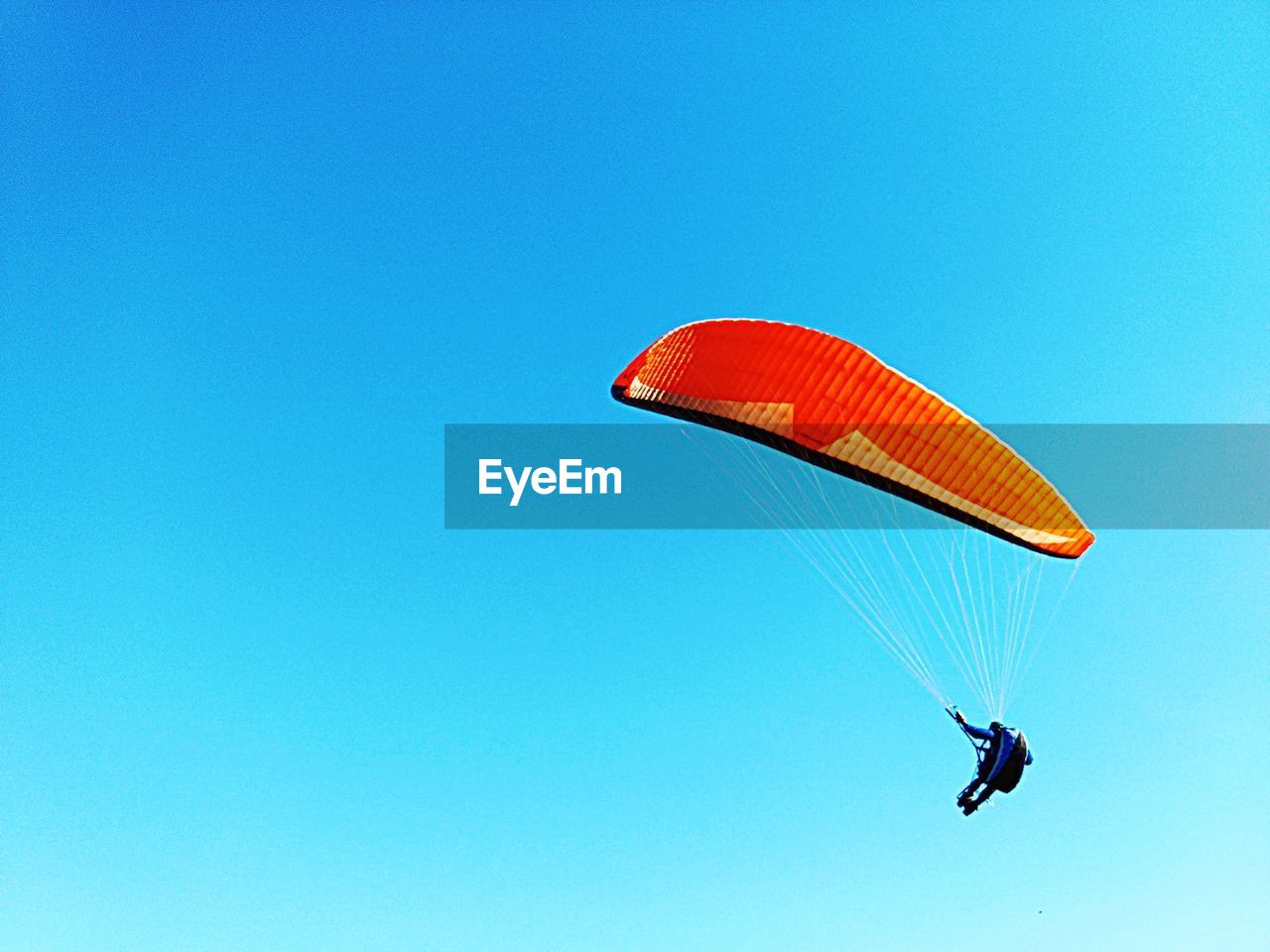 LOW ANGLE VIEW OF KITE FLYING AGAINST CLEAR BLUE SKY