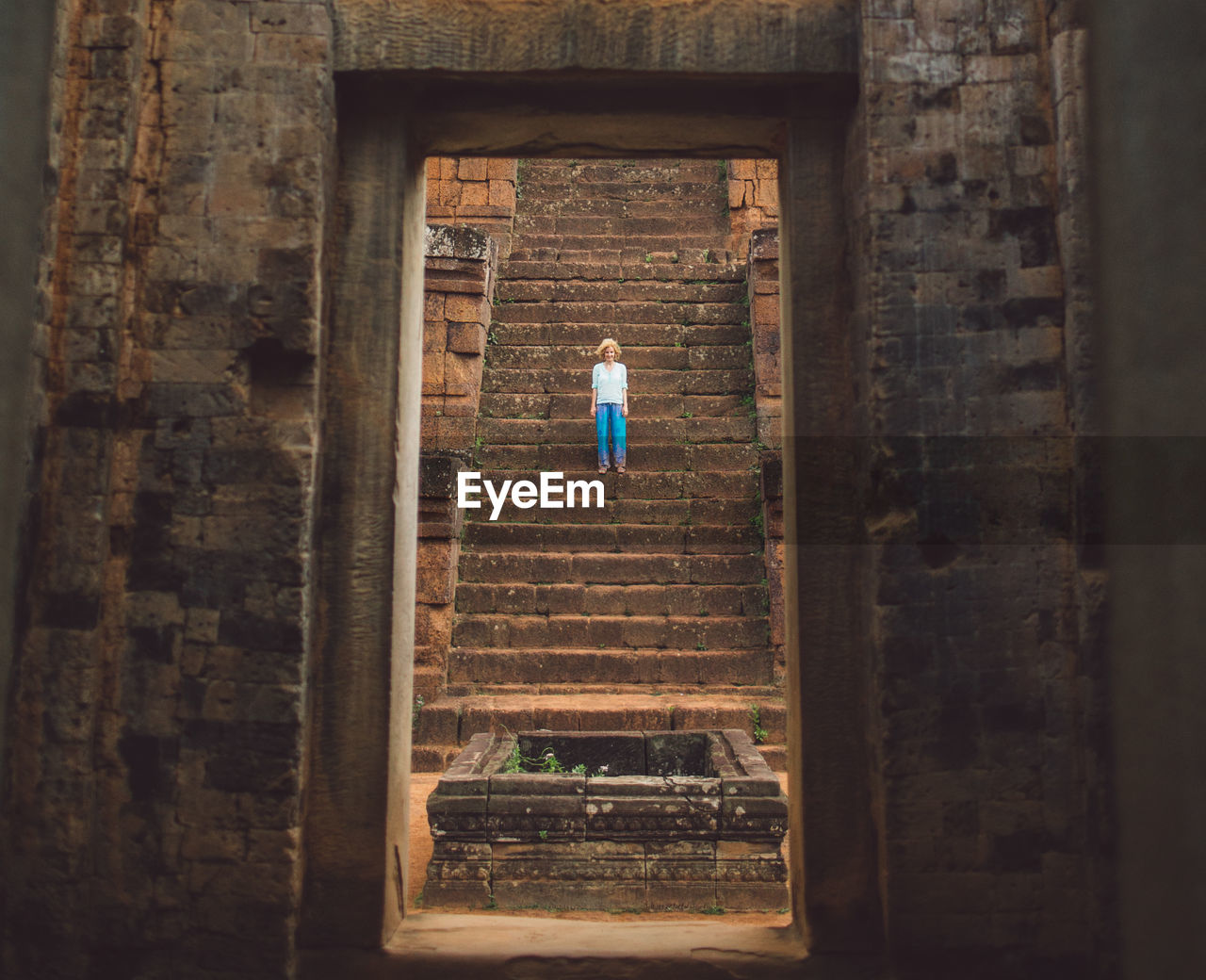 Woman standing on steps at old ruin