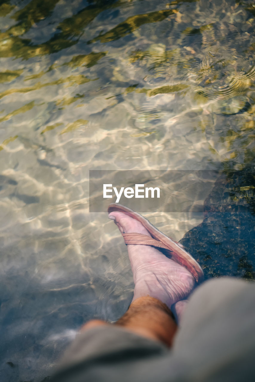 water, reflection, human leg, low section, sea, one person, sunlight, blue, personal perspective, nature, leisure activity, rippled, human foot, high angle view, day, lifestyles, relaxation, limb, adult, wave, human limb, barefoot, sand, outdoors, swimming, ocean, men, shoe, underwater, trip, vacation, motion