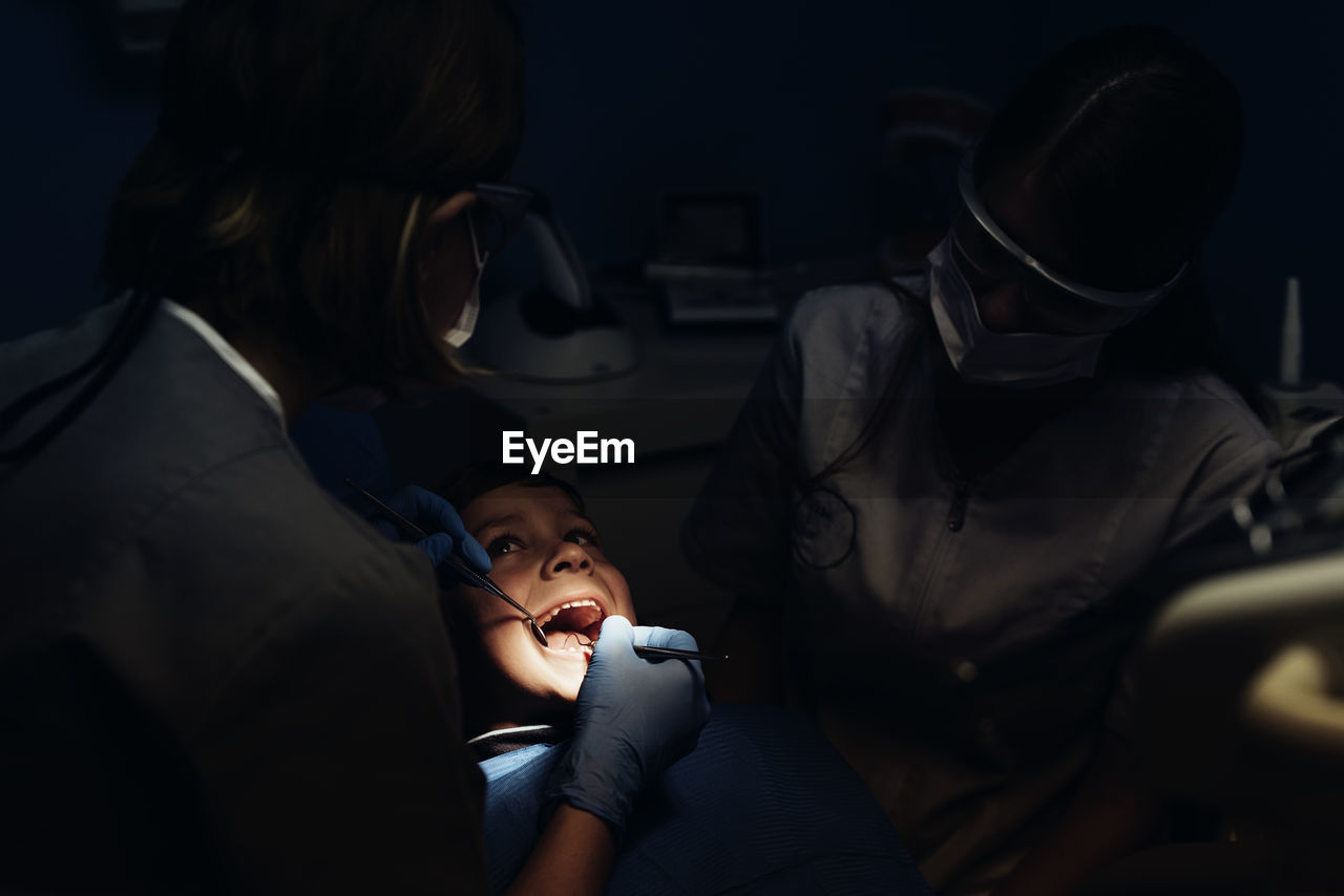 Dentists examining boy in clinic