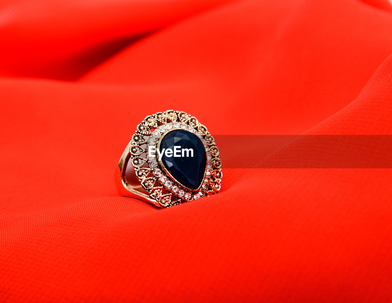 Close up of ring against red background