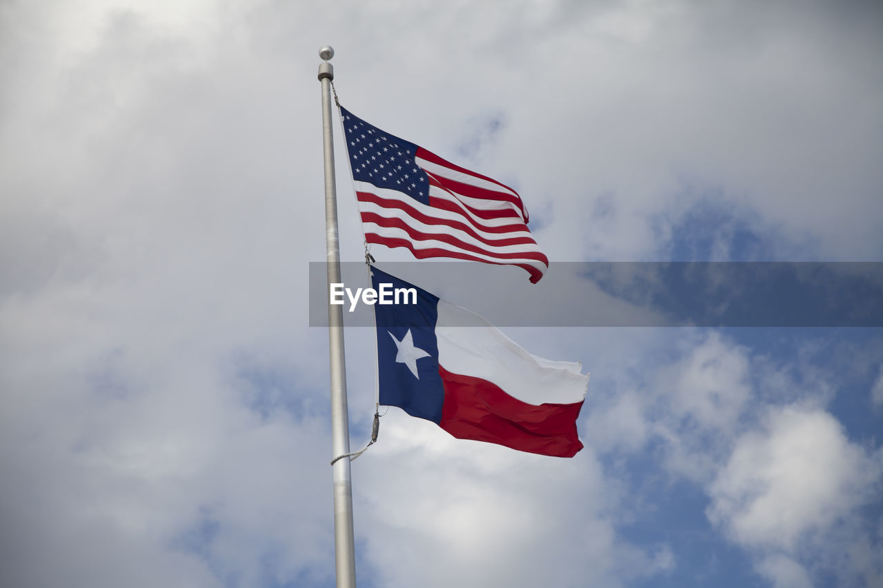 United states and texas state flags billowing in the wind